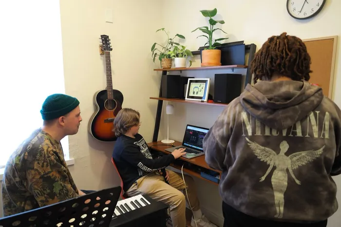 A camper works on a track at a laptop while an instructor looks on